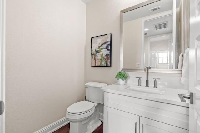 bathroom featuring vanity, hardwood / wood-style flooring, and toilet