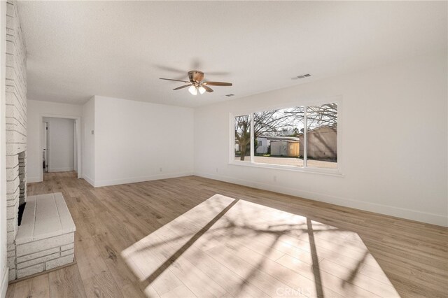 266 E Fig Ln, Corning, CA 96021 - unfurnished bedroom featuring light wood-type flooring, a brick fireplace, and ceiling fan