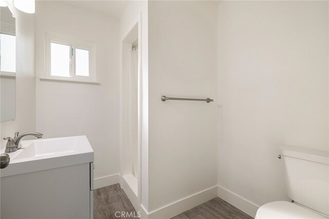 266 E Fig Ln, Corning, CA 96021 - bathroom featuring vanity, toilet, and hardwood / wood-style floors