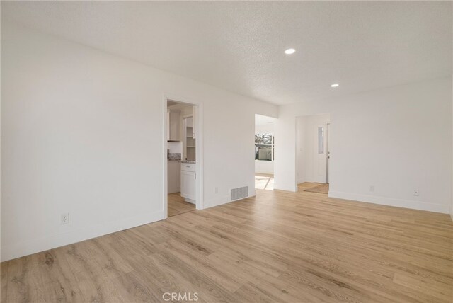 266 E Fig Ln, Corning, CA 96021 - unfurnished room with light wood-type flooring and a textured ceiling