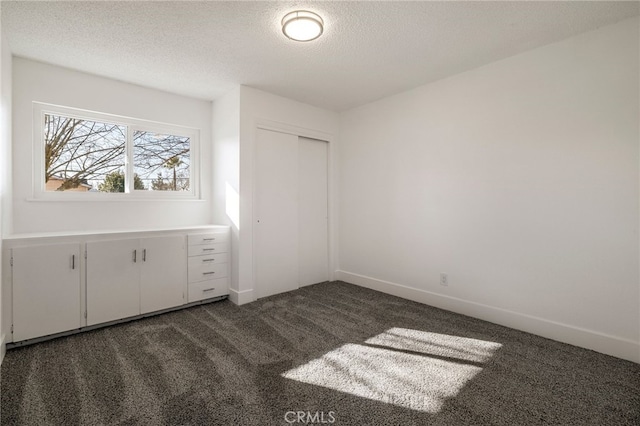 266 E Fig Ln, Corning, CA 96021 - unfurnished bedroom with dark carpet, a textured ceiling, and a closet