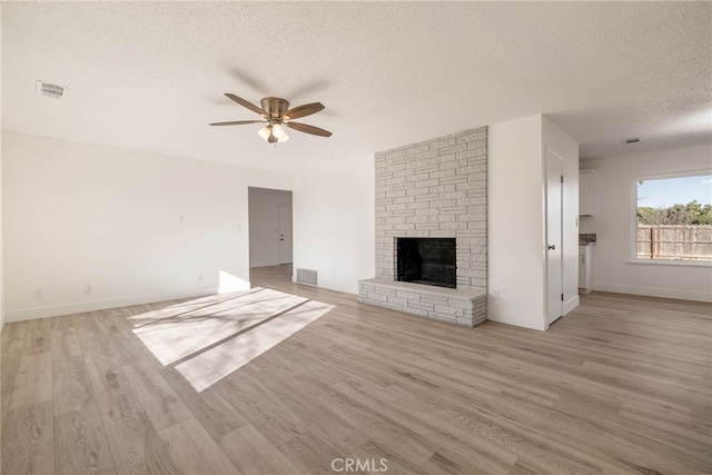 266 E Fig Ln, Corning, CA 96021 - unfurnished living room with a fireplace, ceiling fan, a textured ceiling, and light hardwood / wood-style floors