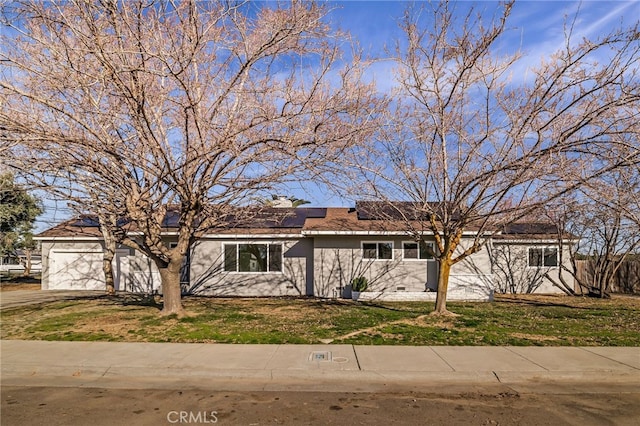 ranch-style house featuring a garage and a front lawn