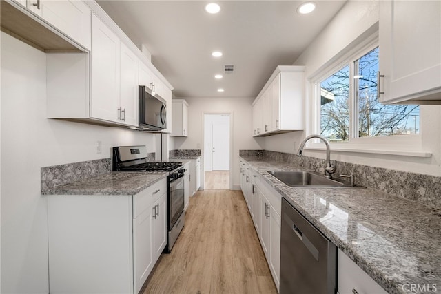 266 E Fig Ln, Corning, CA 96021 - kitchen featuring light stone countertops, light hardwood / wood-style floors, sink, appliances with stainless steel finishes, and white cabinets