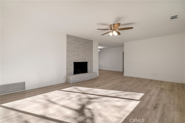 266 E Fig Ln, Corning, CA 96021 - unfurnished living room with a fireplace, ceiling fan, and light hardwood / wood-style flooring