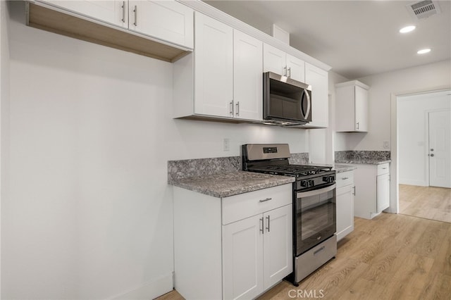 266 E Fig Ln, Corning, CA 96021 - kitchen featuring light hardwood / wood-style floors, stainless steel appliances, white cabinets, and stone counters
