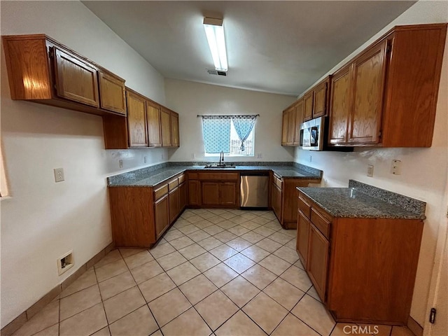 kitchen featuring appliances with stainless steel finishes, brown cabinets, a sink, and visible vents