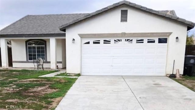 ranch-style home with driveway, an attached garage, and stucco siding