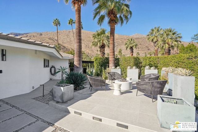 view of patio with a mountain view and a fire pit