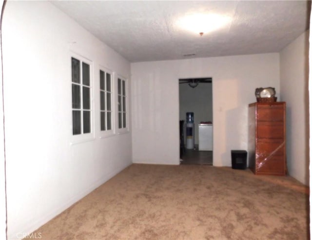 carpeted empty room with a textured ceiling