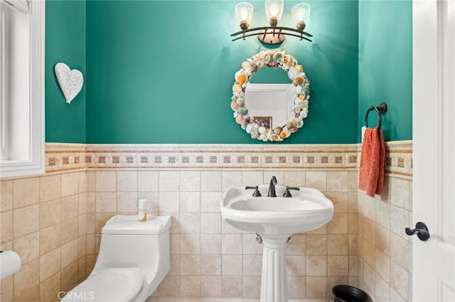 bathroom with toilet and tile walls