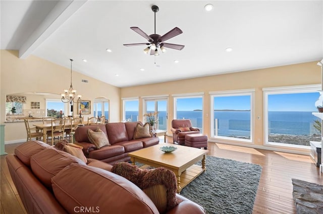 living room with lofted ceiling with beams, light hardwood / wood-style floors, a water view, and a healthy amount of sunlight