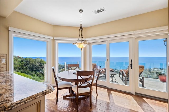 dining room featuring a water view and hardwood / wood-style floors