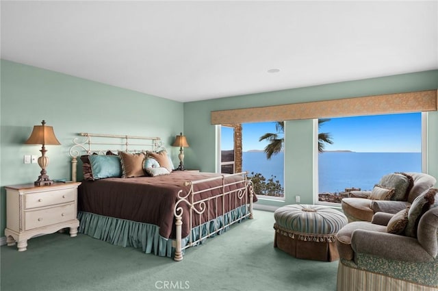 bedroom with a water view and carpet flooring