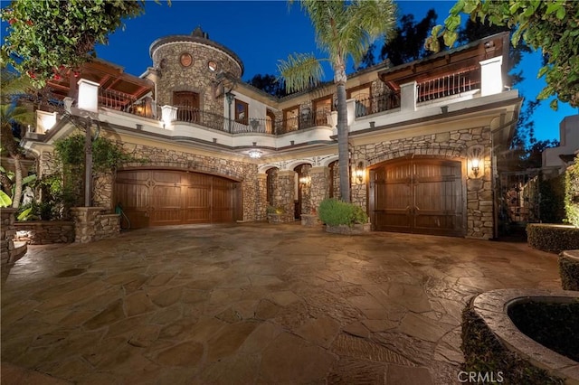 mediterranean / spanish-style house featuring a garage and a balcony