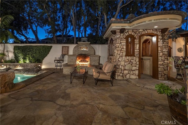 patio at twilight with exterior fireplace