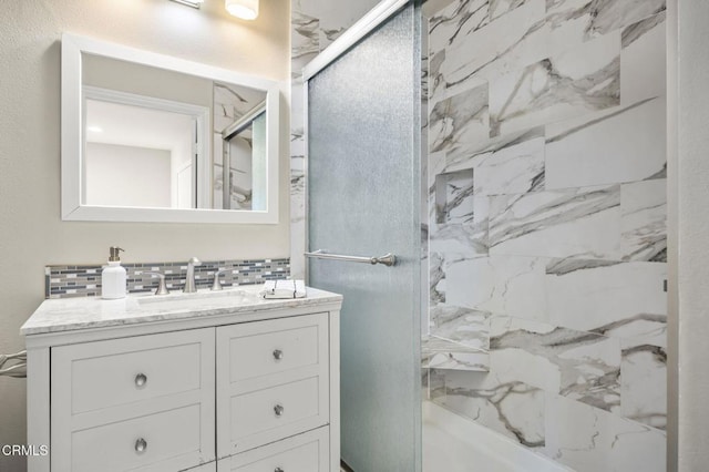 bathroom featuring vanity, a shower with door, and backsplash