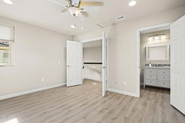 unfurnished bedroom featuring sink, connected bathroom, and light hardwood / wood-style floors