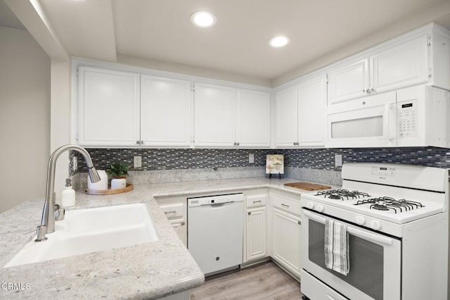 kitchen with sink, white cabinets, white appliances, and decorative backsplash