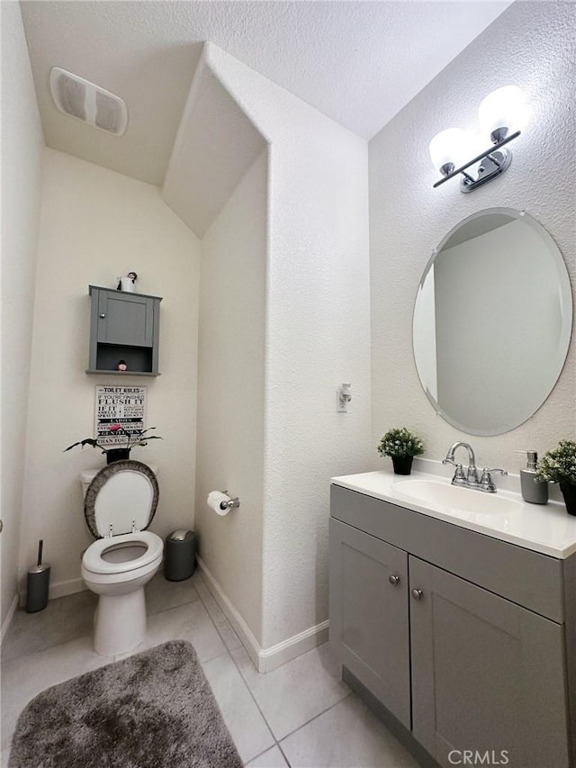 bathroom with tile patterned flooring, vanity, a textured ceiling, and toilet