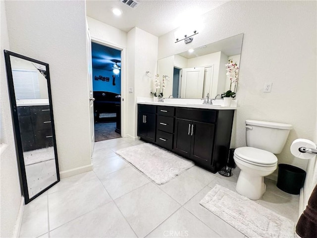 bathroom featuring ceiling fan, tile patterned flooring, vanity, a textured ceiling, and toilet