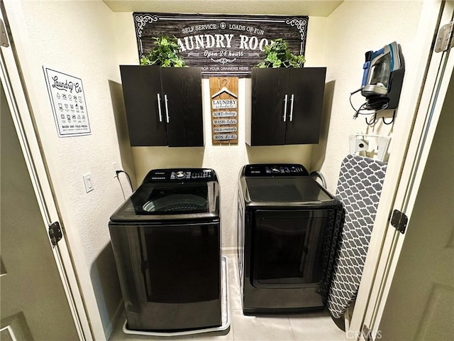 laundry room featuring tile patterned floors, cabinets, and washing machine and clothes dryer