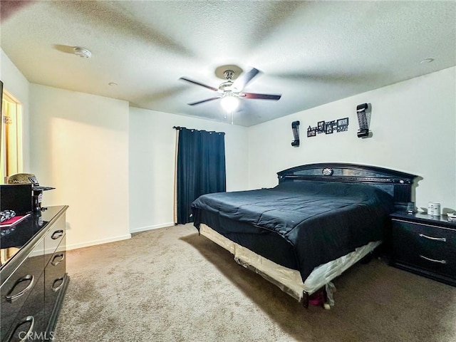 carpeted bedroom featuring ceiling fan and a textured ceiling