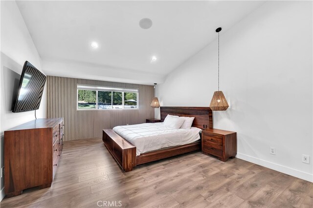 bedroom featuring vaulted ceiling and light hardwood / wood-style floors