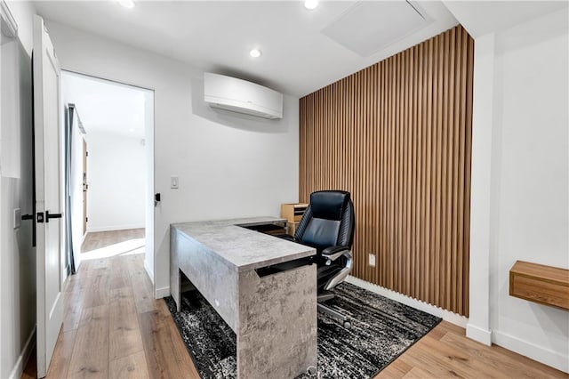 office with a wall unit AC and light wood-type flooring