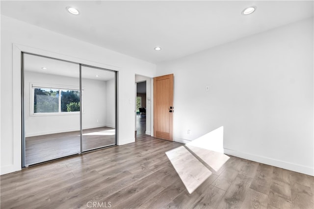 unfurnished bedroom featuring a closet and light wood-type flooring