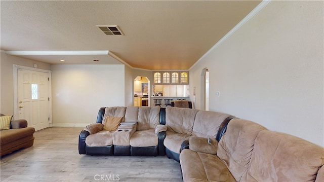 living room with crown molding, light hardwood / wood-style flooring, and a textured ceiling