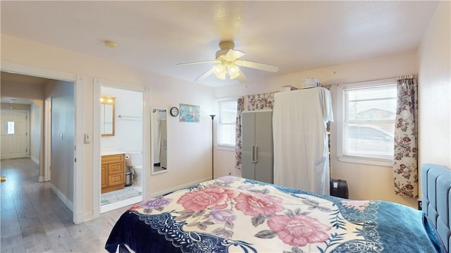 bedroom featuring light hardwood / wood-style floors, ensuite bath, and ceiling fan