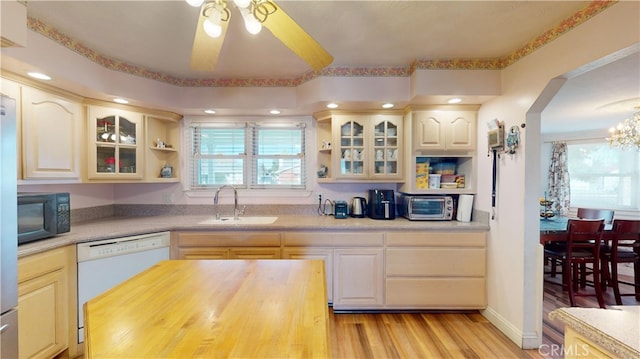 kitchen with sink, ceiling fan, light hardwood / wood-style floors, and white dishwasher