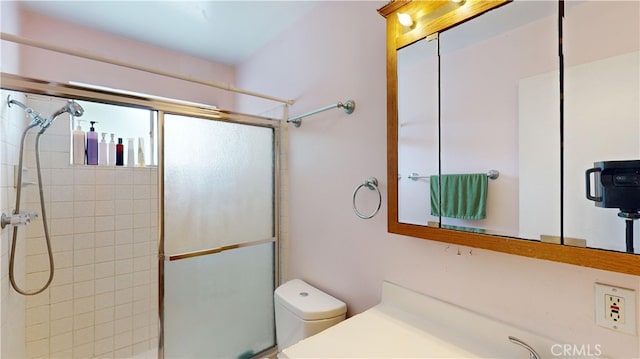 bathroom featuring toilet, an enclosed shower, and vanity