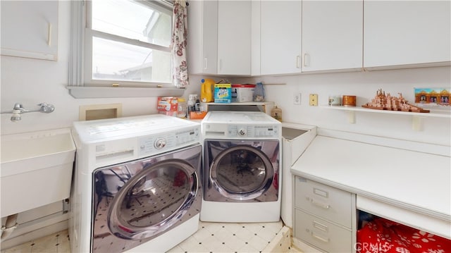 laundry room featuring cabinets, sink, and independent washer and dryer