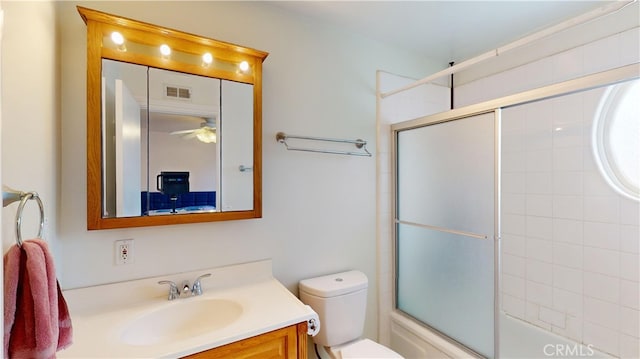 full bathroom featuring toilet, enclosed tub / shower combo, and vanity