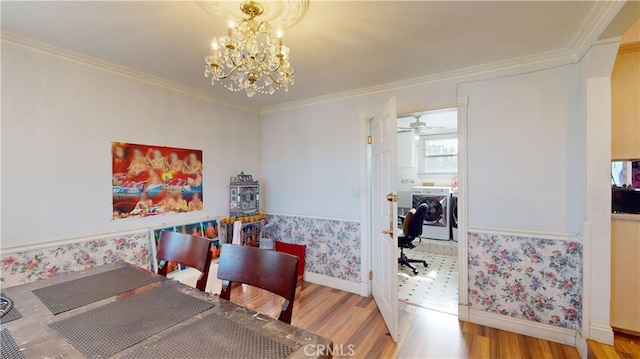 dining room featuring light hardwood / wood-style flooring, crown molding, independent washer and dryer, and an inviting chandelier