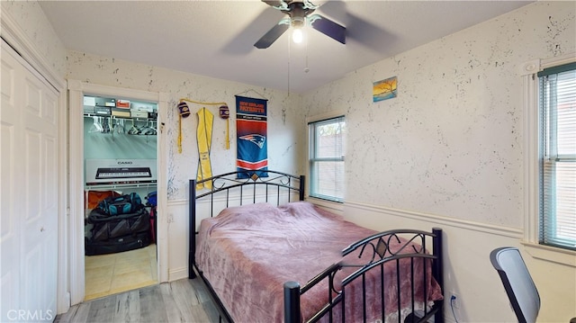 bedroom with ceiling fan, multiple windows, and light hardwood / wood-style flooring