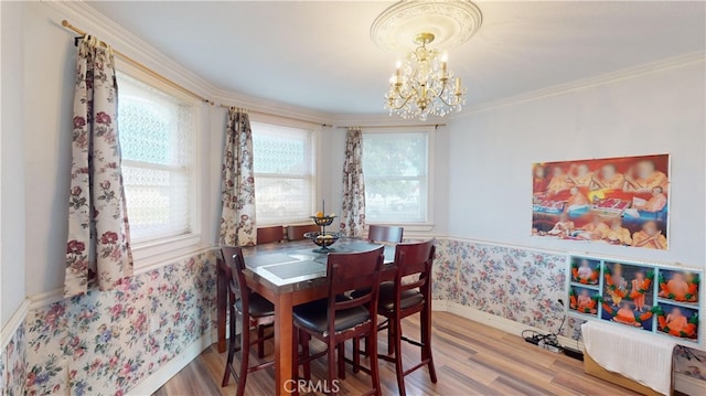 dining area with wood-type flooring, crown molding, and an inviting chandelier