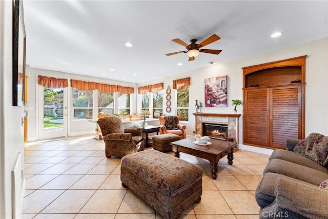 tiled living room with ceiling fan and a high end fireplace