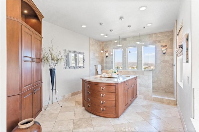 bathroom with tile patterned floors, vanity, and a tile shower