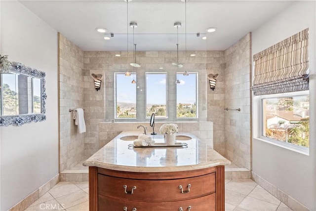 bathroom with tile patterned floors, vanity, and tiled shower