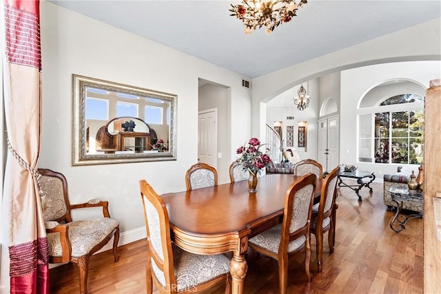 dining room featuring wood-type flooring and an inviting chandelier