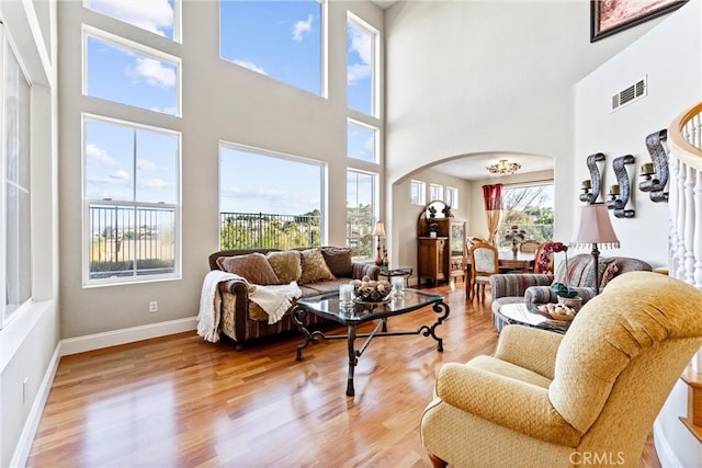 living room with a high ceiling and light wood-type flooring