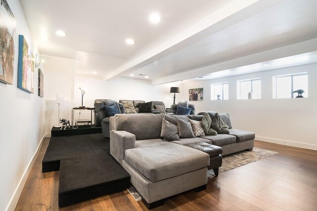 home theater room with dark hardwood / wood-style flooring and beamed ceiling