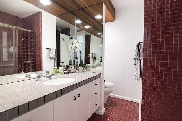 full bath featuring baseboards, toilet, tile patterned floors, vanity, and a shower stall