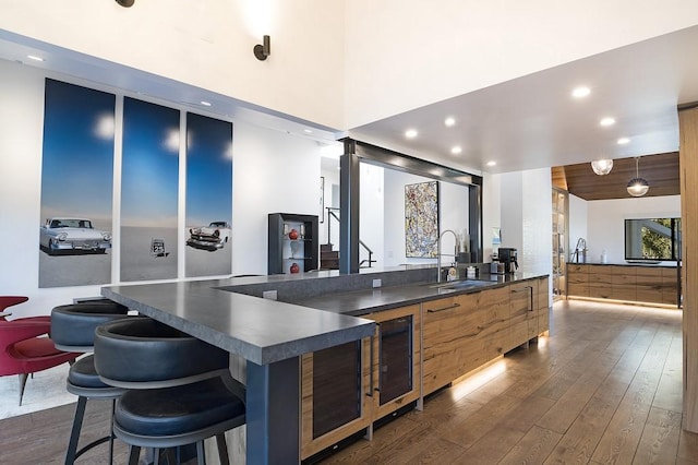 bar with beverage cooler, dark wood-style flooring, a sink, and recessed lighting