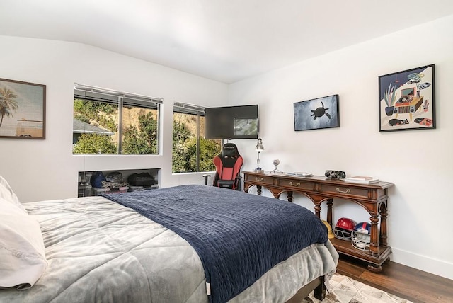 bedroom with lofted ceiling and wood-type flooring