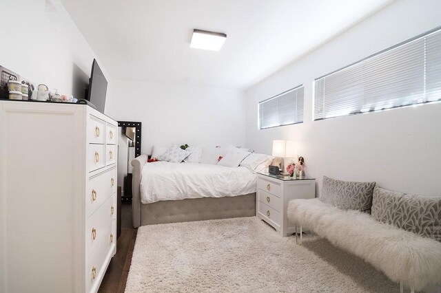 bedroom with dark hardwood / wood-style floors