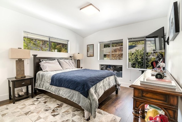 bedroom featuring vaulted ceiling, light wood-type flooring, and baseboards